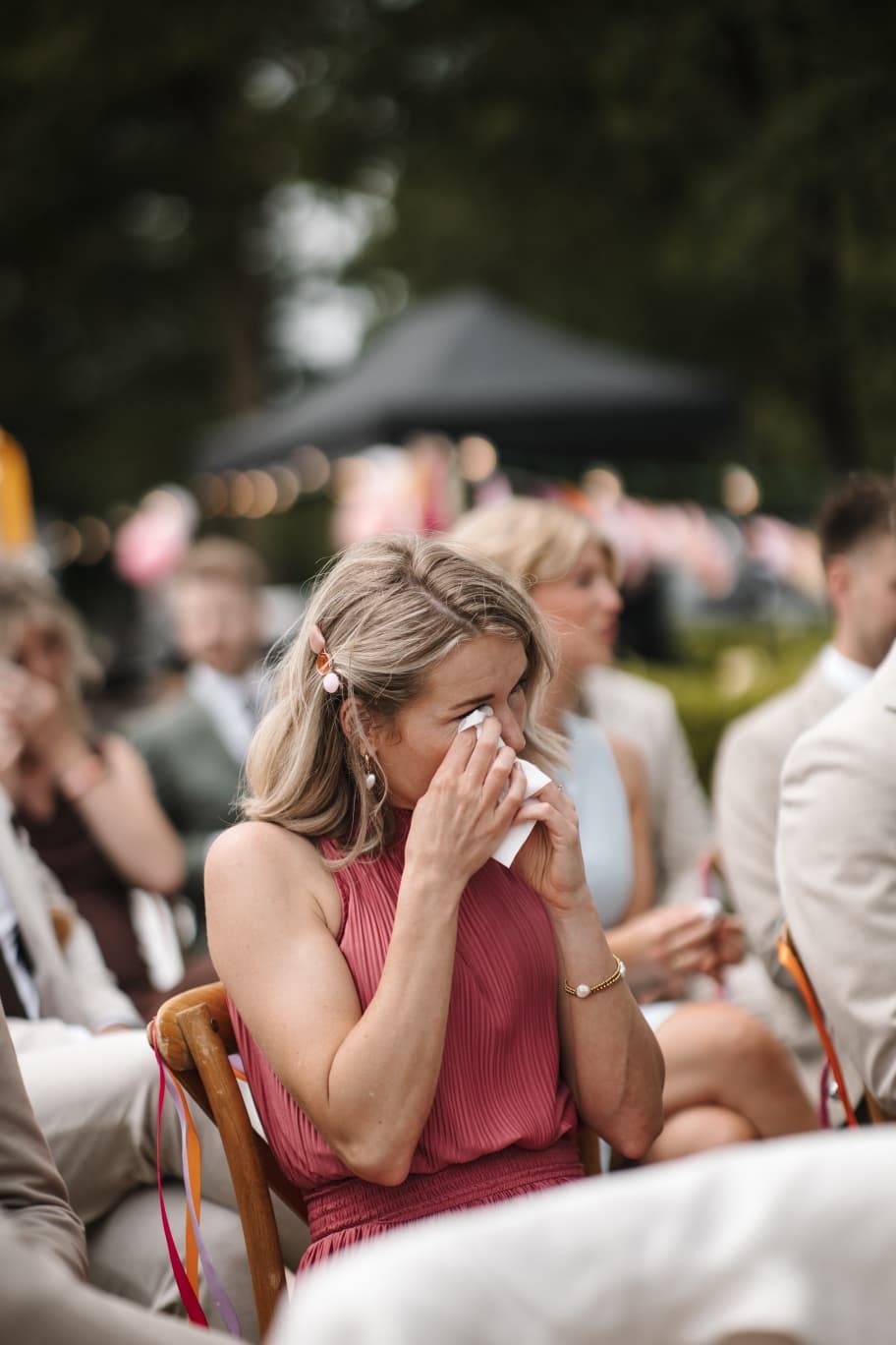 Gast pinkt een traantje weg tijdens de ceremonie
